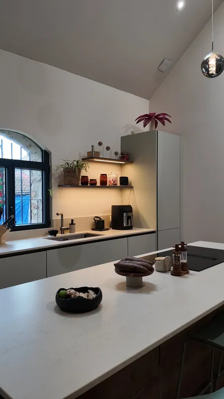 Cuisine blanche contemporaine avec plan de travail en pierre et niche en…, réalisée par Cuisines ELITE Chelles, vue 1 sur 7