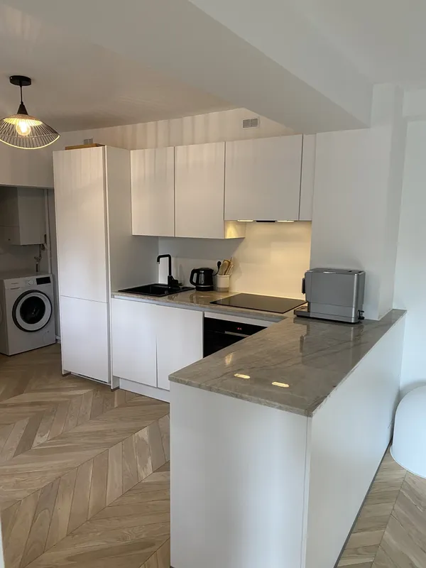 Petite cuisine en L avec plan de travail en pierre, réalisée par Cuisines ELITE Asnières-sur-Seine, vue 1 sur 3