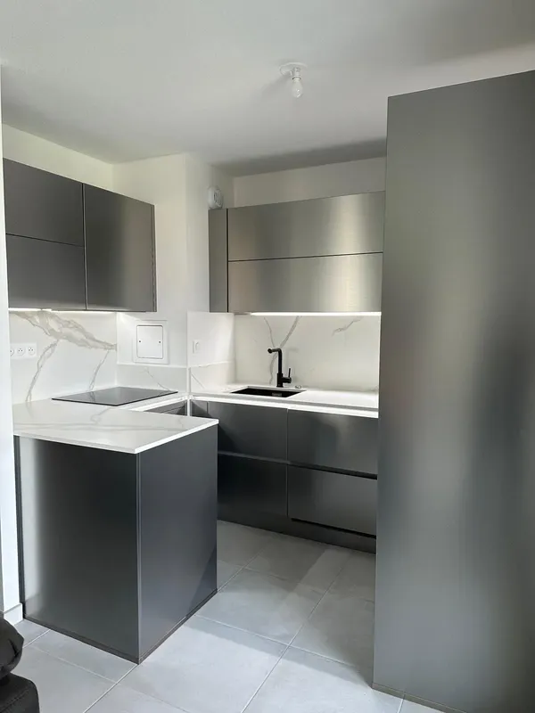 Cuisine en inox et céramique effet marbre : l'alliance du design et de…, réalisée par Cuisines ELITE Mulhouse, vue 1 sur 3
